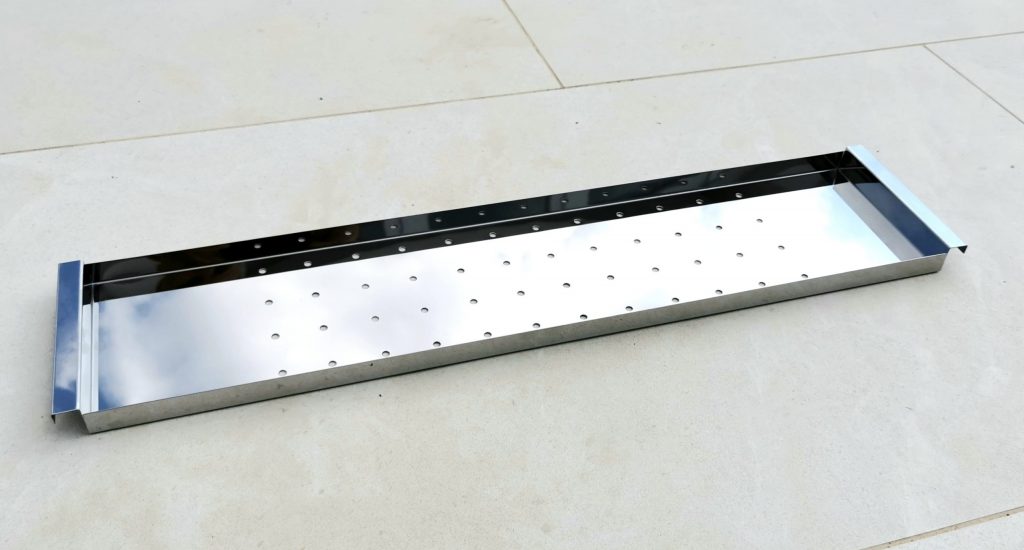 Stainless warming rack mounted on the grill shield keeping food warm