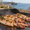 Squid cooking on the hot steel plate of a gas grill